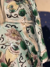 A Chinese verte biscuit figure, a green 'lotus' jar and a figurative blue and white plate, Kangxi and later